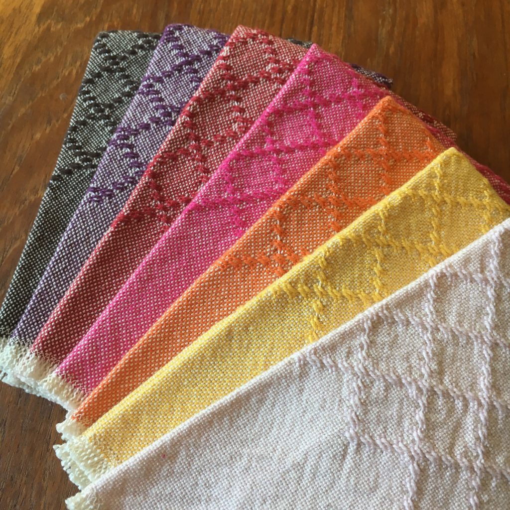 Set of seven colorful huck lace cotton napkins, finished with a simple zigzag stitch and fringe, ready for a picnic